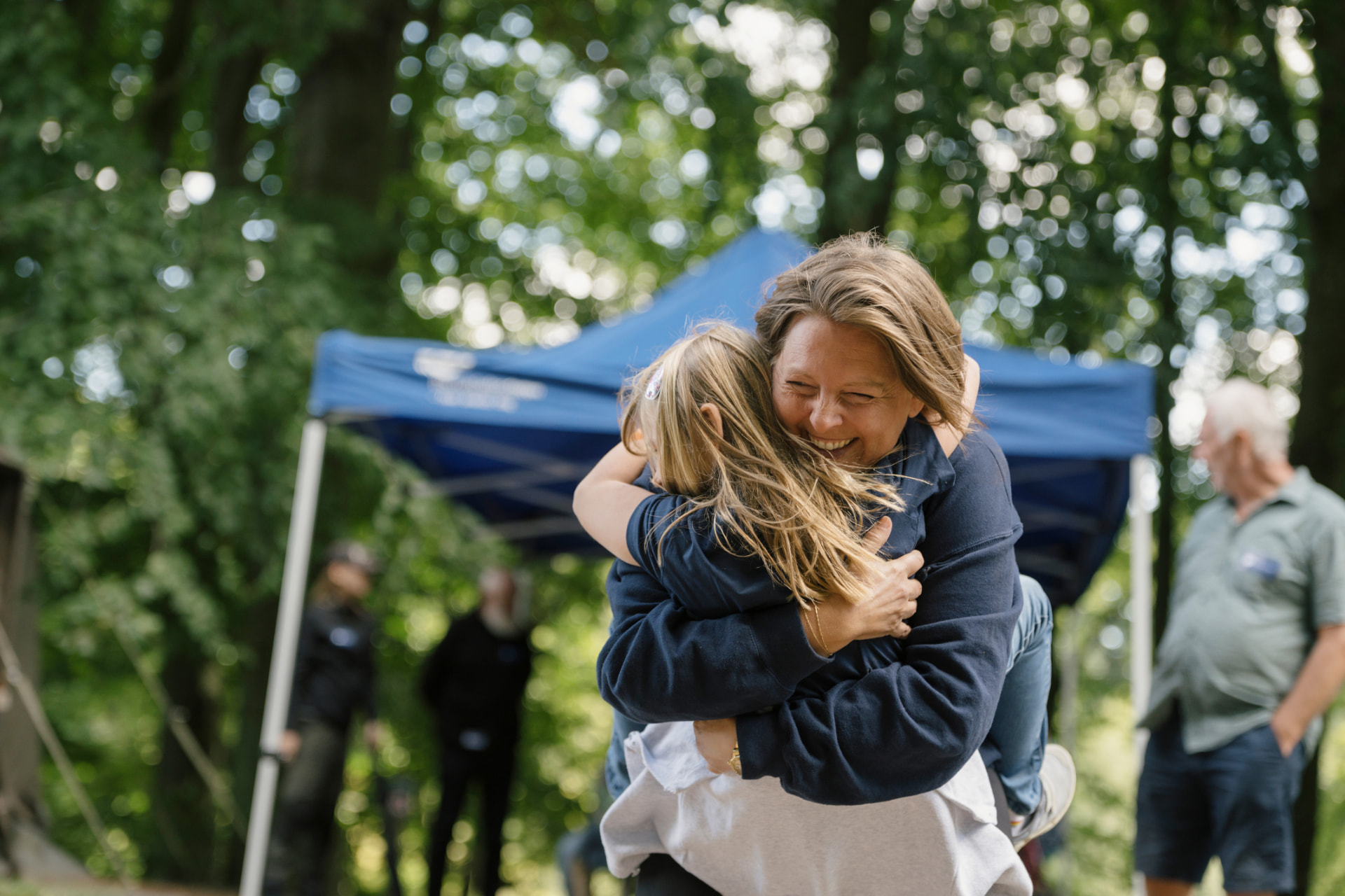 Voksen og barn krammer i Ree Park
